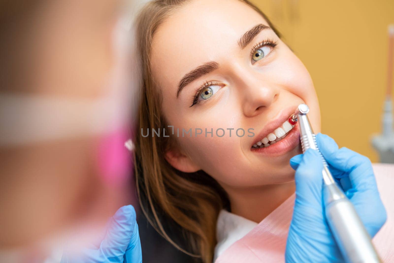 Dentist performing teeth grinding procedure in dental clinic. Woman visits doctor grinding teeth to create perfect smile in private hospital