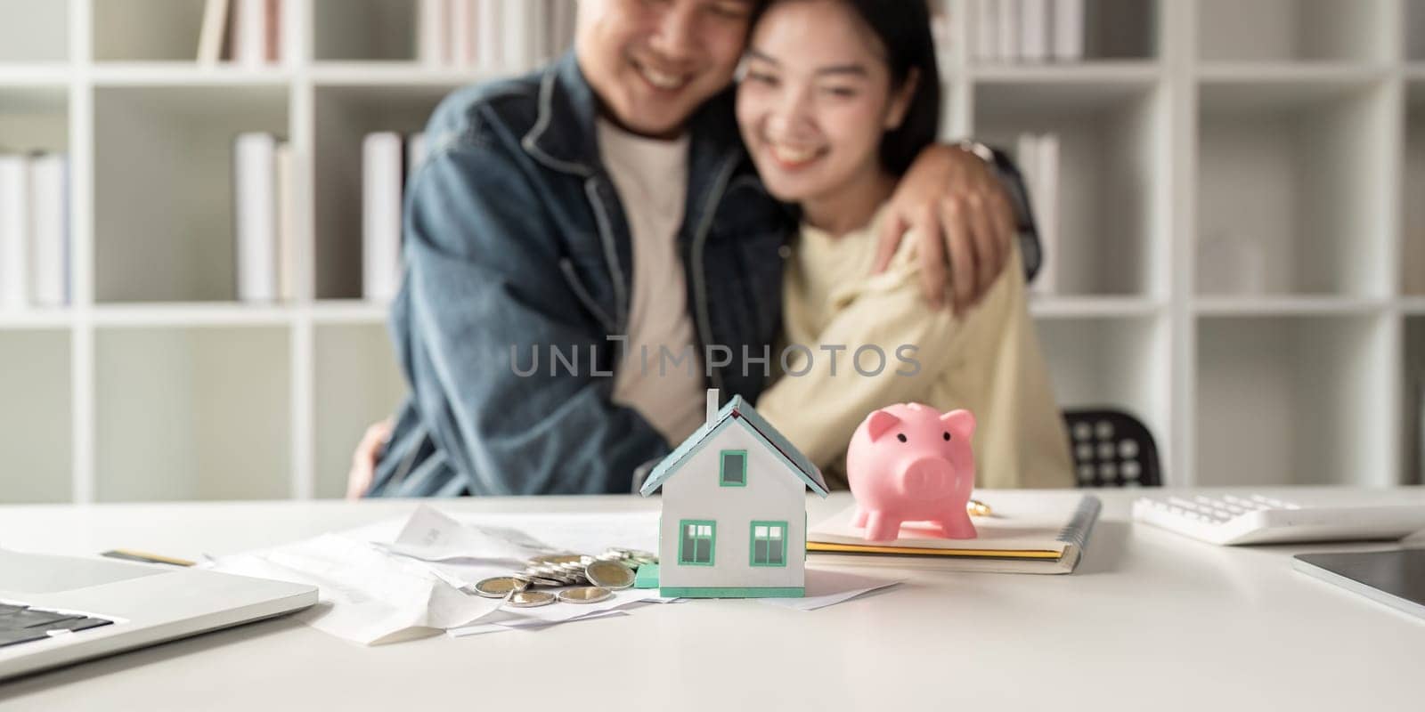 Happy asian family young couple love hand . piggy bank to save and model home for saving money to buy for new home. deposit with bank for financial plan.