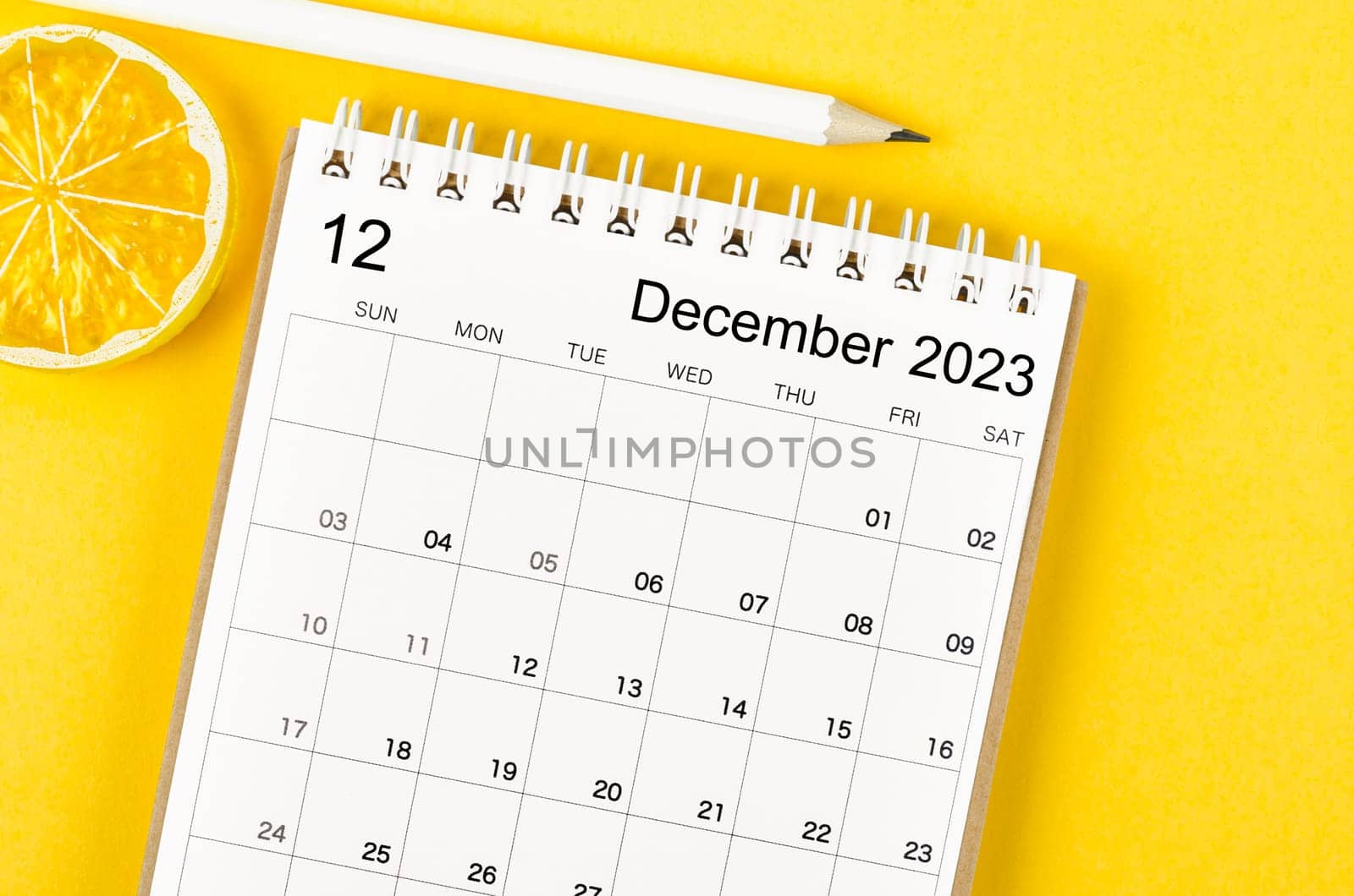 October 2023 Monthly desk calendar for 2023 year with wooden pencil on yellow background.