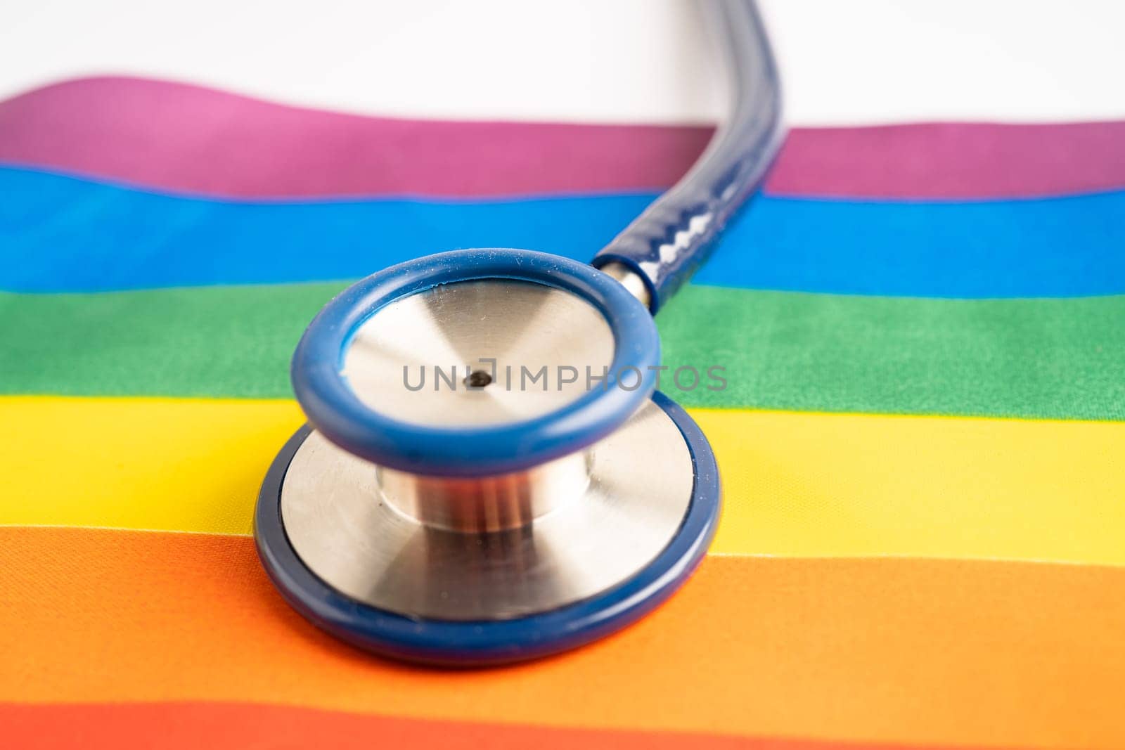 Black stethoscope on rainbow flag background, symbol of LGBT pride month celebrate annual in June social, symbol of gay, lesbian, bisexual, transgender, human rights and peace. by pamai