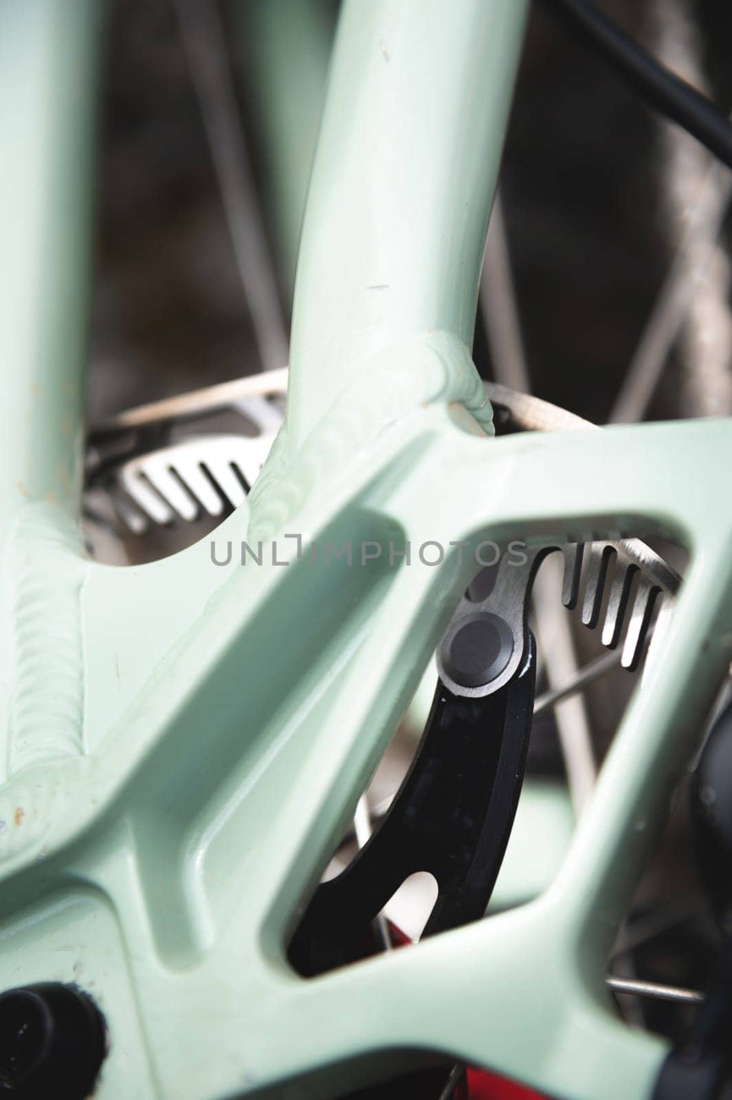 Close-up of a mountain bike element. Shallow depth of field frame detail and brake disc of mountain bike hydraulic brakes.