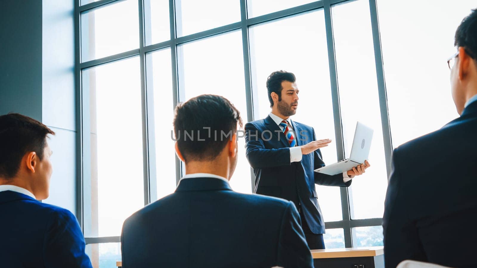 Group of business people meeting in a seminar conference . Audience listening to instructor in employee education training session . Office worker community summit forum with expert speaker . Jivy