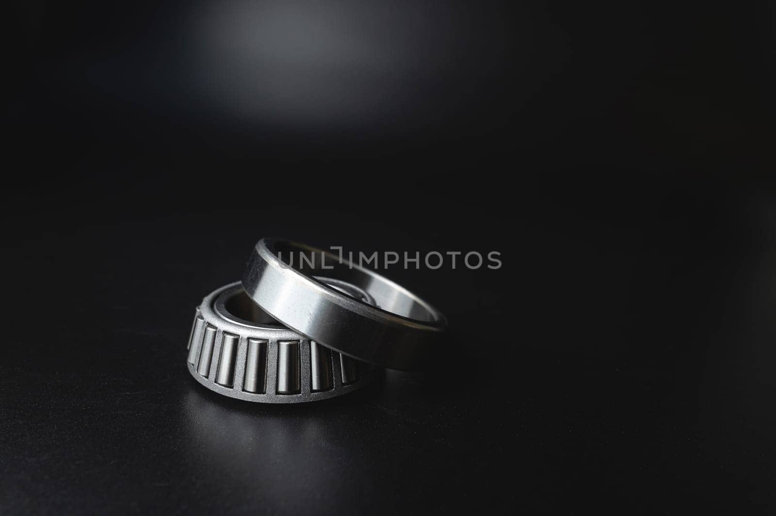 New angular contact roller bearing of a new hub close-up, auto parts on a black background by yanik88