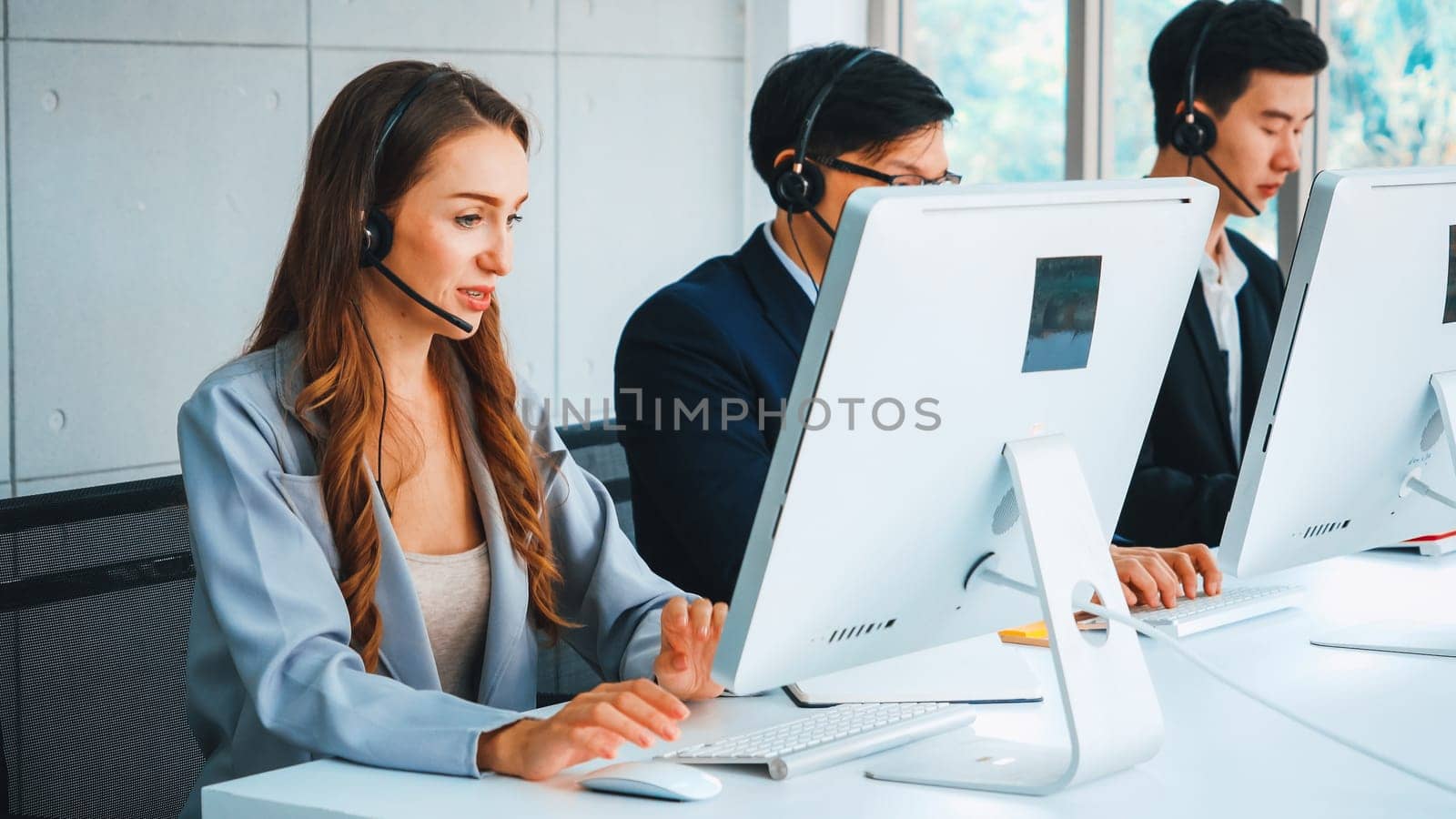 Business people wearing headset working in office to support remote customer or colleague. Call center, telemarketing, customer support agent provide service on telephone video conference call. Jivy