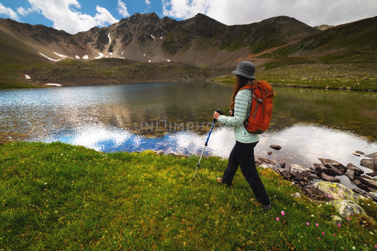Man traveler walking along beautiful views of mountains and lakes. A woman goes on a trip and walks in the mountains. Beautiful view by yanik88
