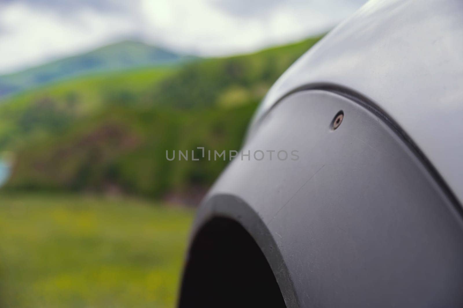 wheel under the fender of an SUV, extreme off-road ride, close-up of the fender of a clean car. green mountains can be seen in the background by yanik88