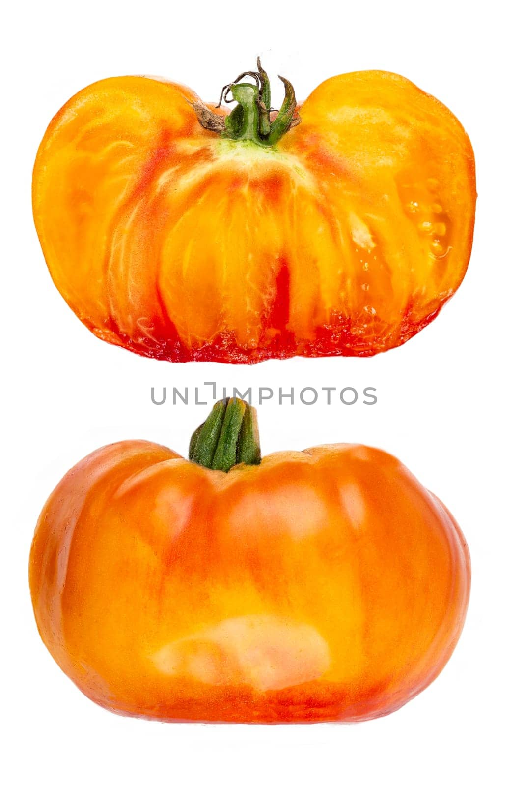 Studio shot of half yellow and orange tomatoes on white background