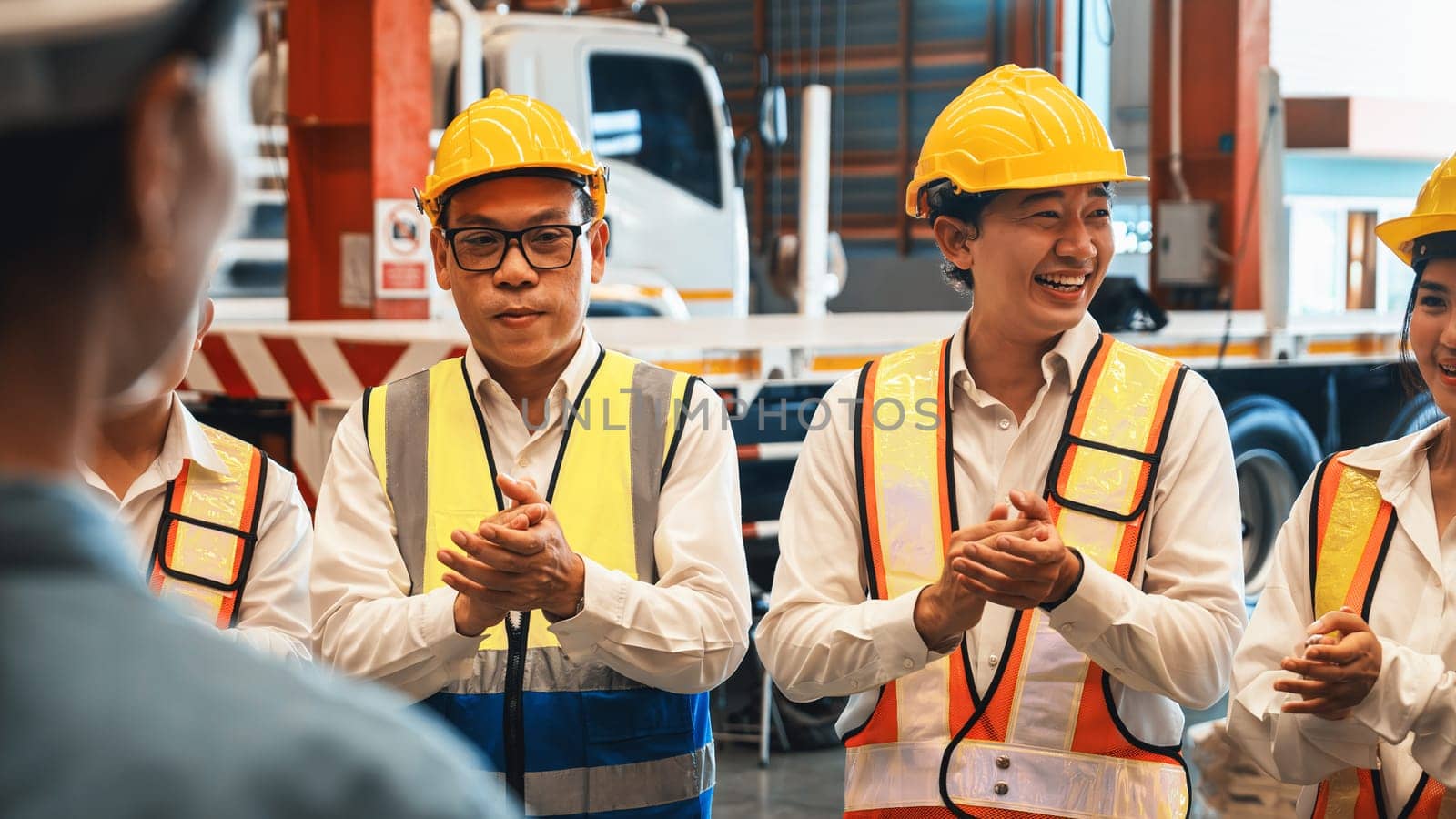 Happiness and joyful atmosphere, smiling factory worker and engineer celebrate with factory executive or manager after achieve factory output and surpassing the maximum quota. Exemplifying