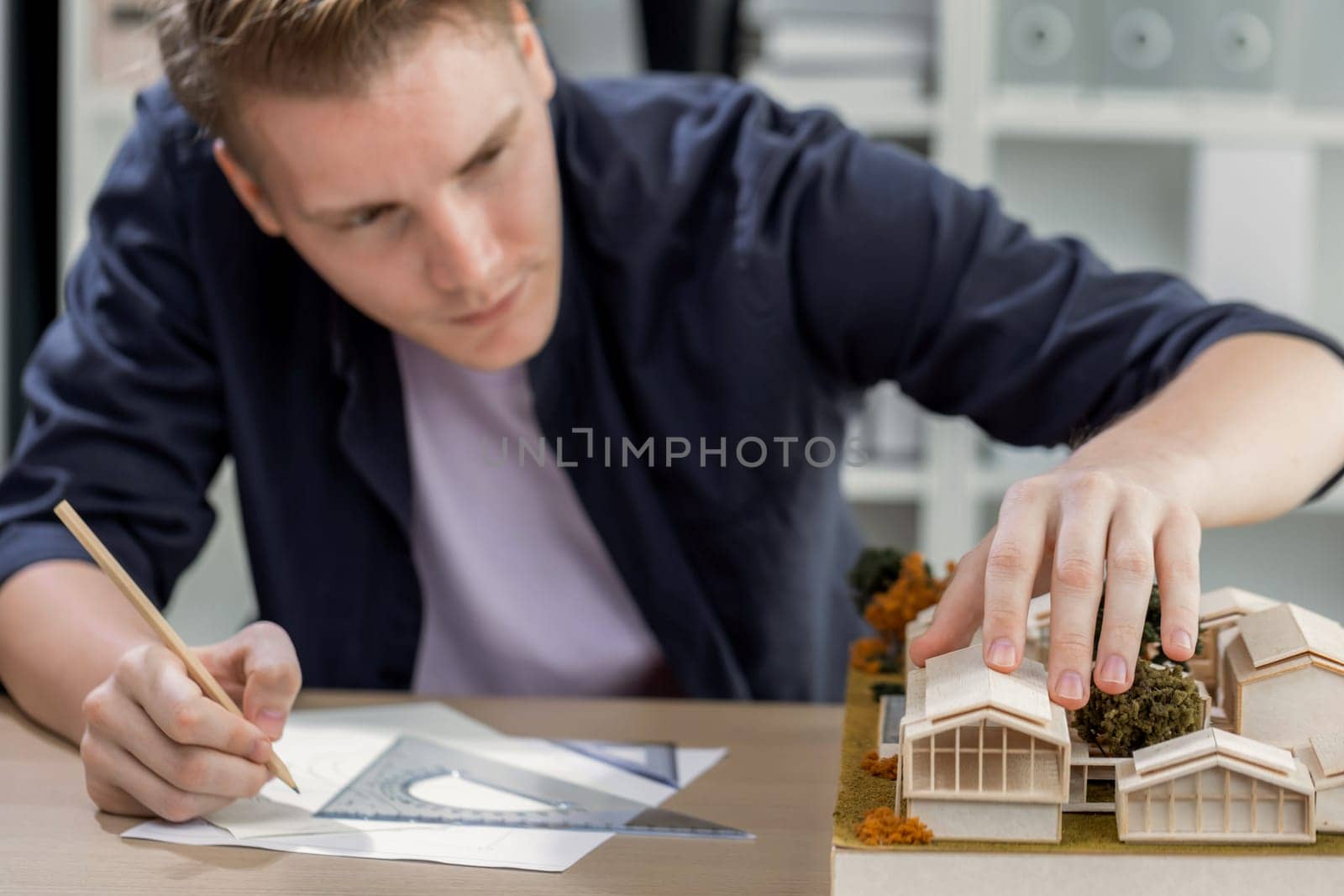 Architect designer studies elegant house model, reviewing structure design for improvement with construction plan on table. Creativity and innovation in architectural design. Iteration