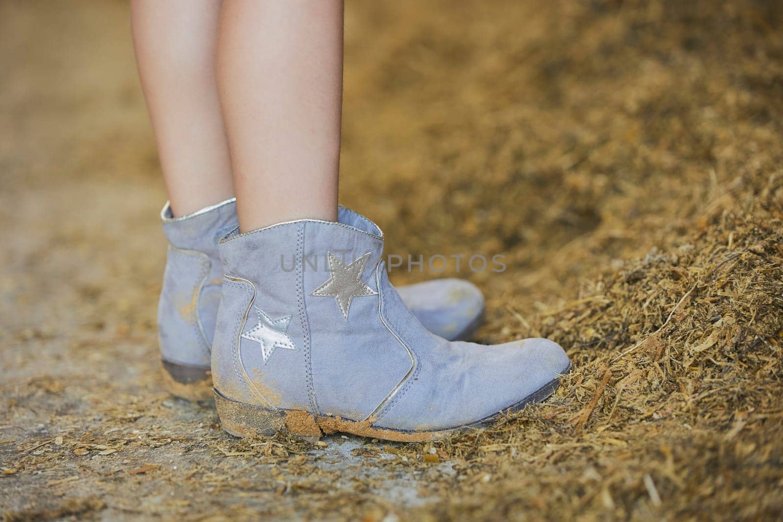 Little girl in cowboy boots on a farm in Denmark.
