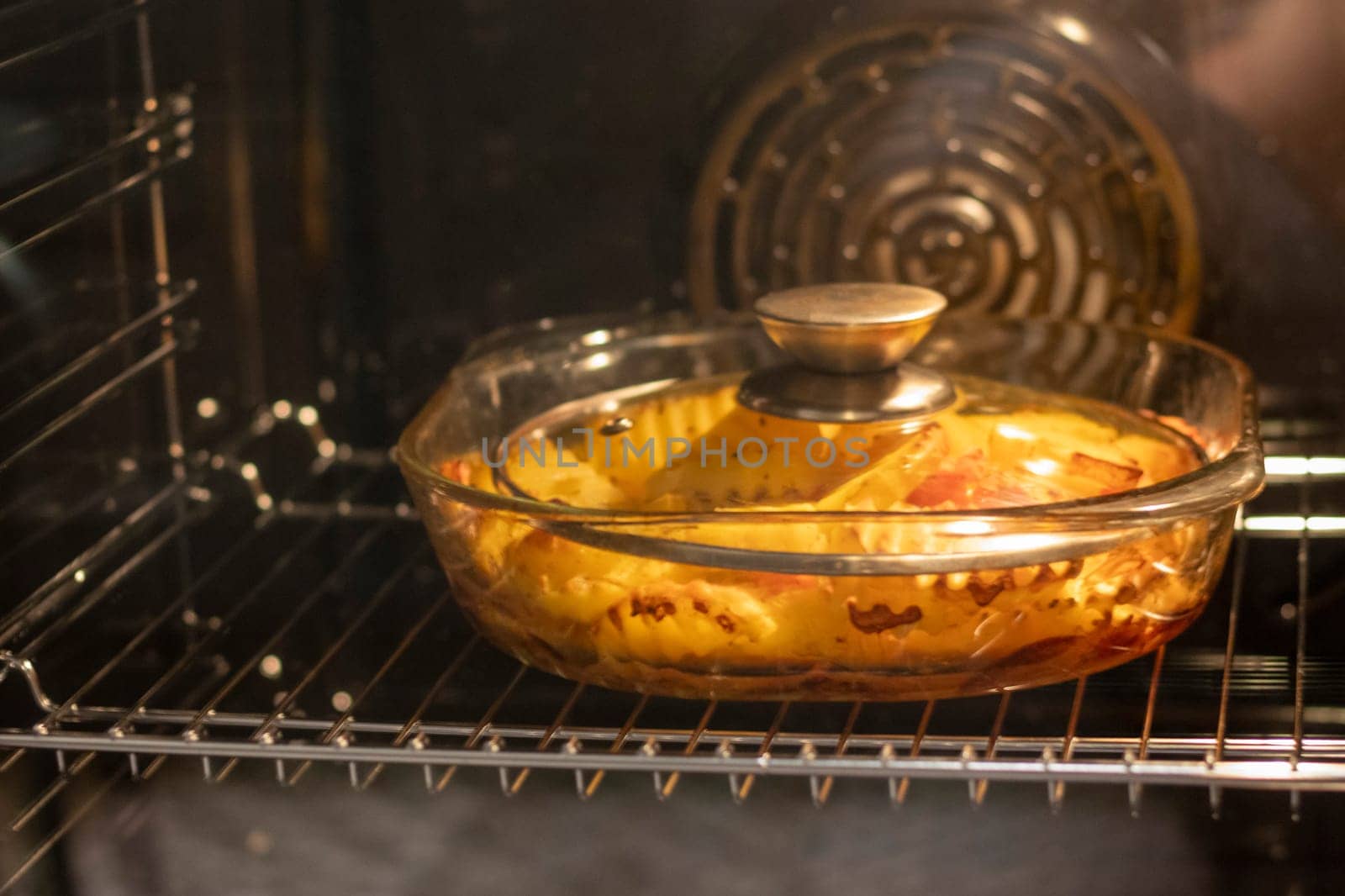 Vegetables baking in the transparent dish in the oven.
