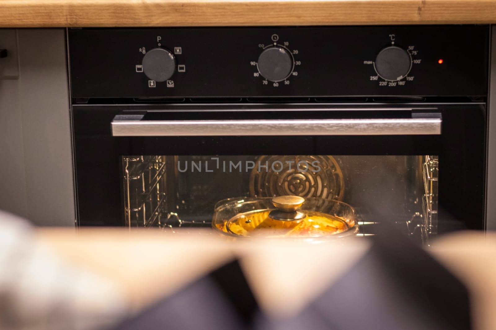 Vegetables baking in the transparent dish in the oven.