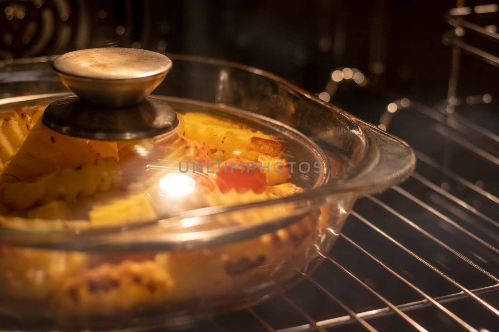 Vegetables baking in the transparent dish in the oven.