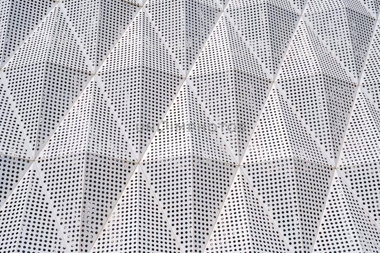facade of a modern building is covered with geometric metal aluminum panels