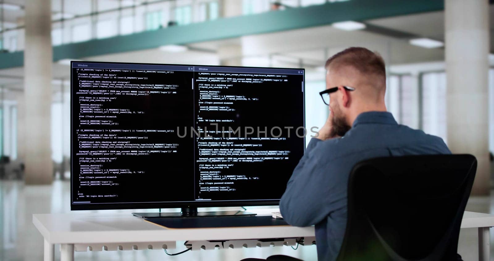 Computer Programmer Writing Program Code On Computer In Office
