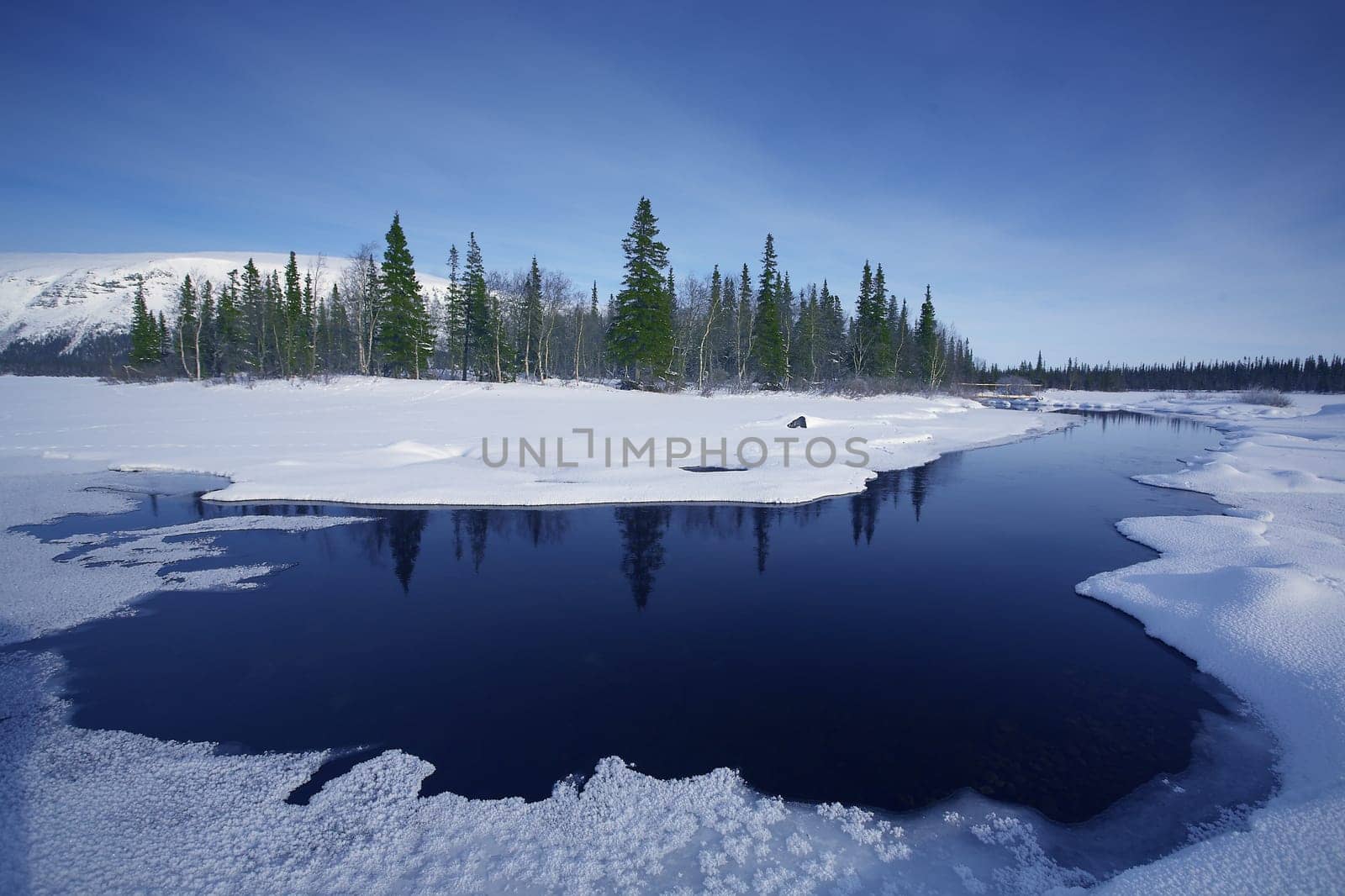 beautiful arctic winter landscape with snowy forest and frozen lake, very cold climate,