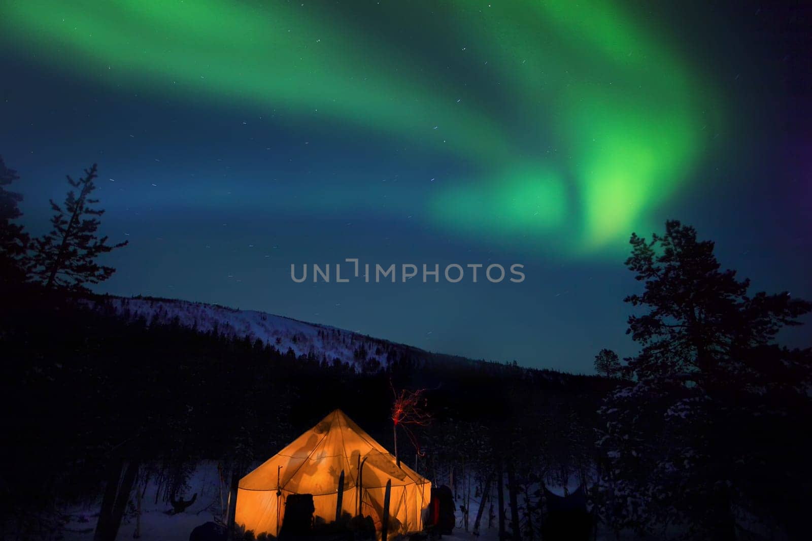 beautiful arctic winter landscape with northern lights, beautiful arctic winter landscape with snowy forest in the background, blue sky and sun setting on the horizon. cold climate