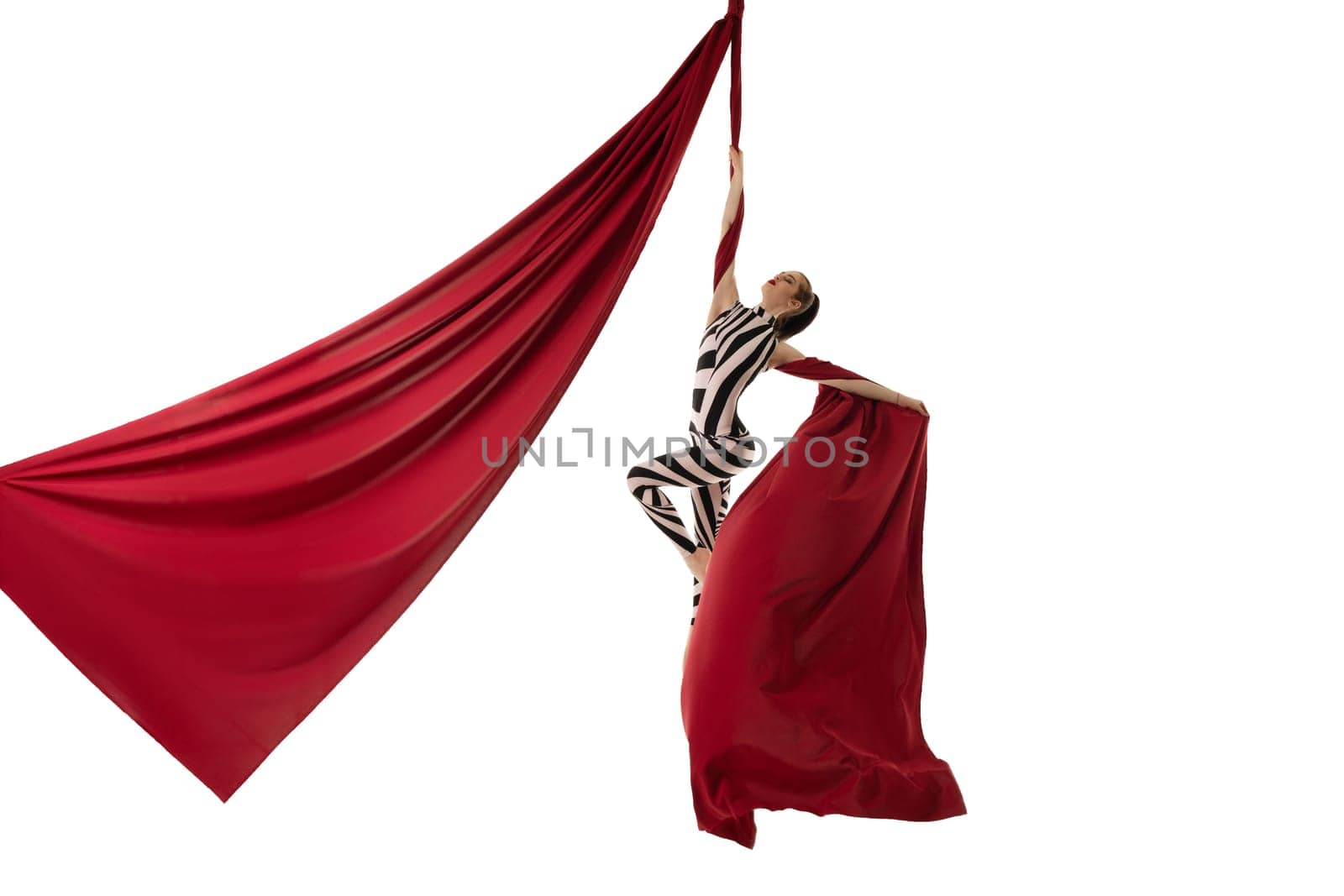 Beautiful girl in striped body hanging gracefully on burgundy cloth isolated shot