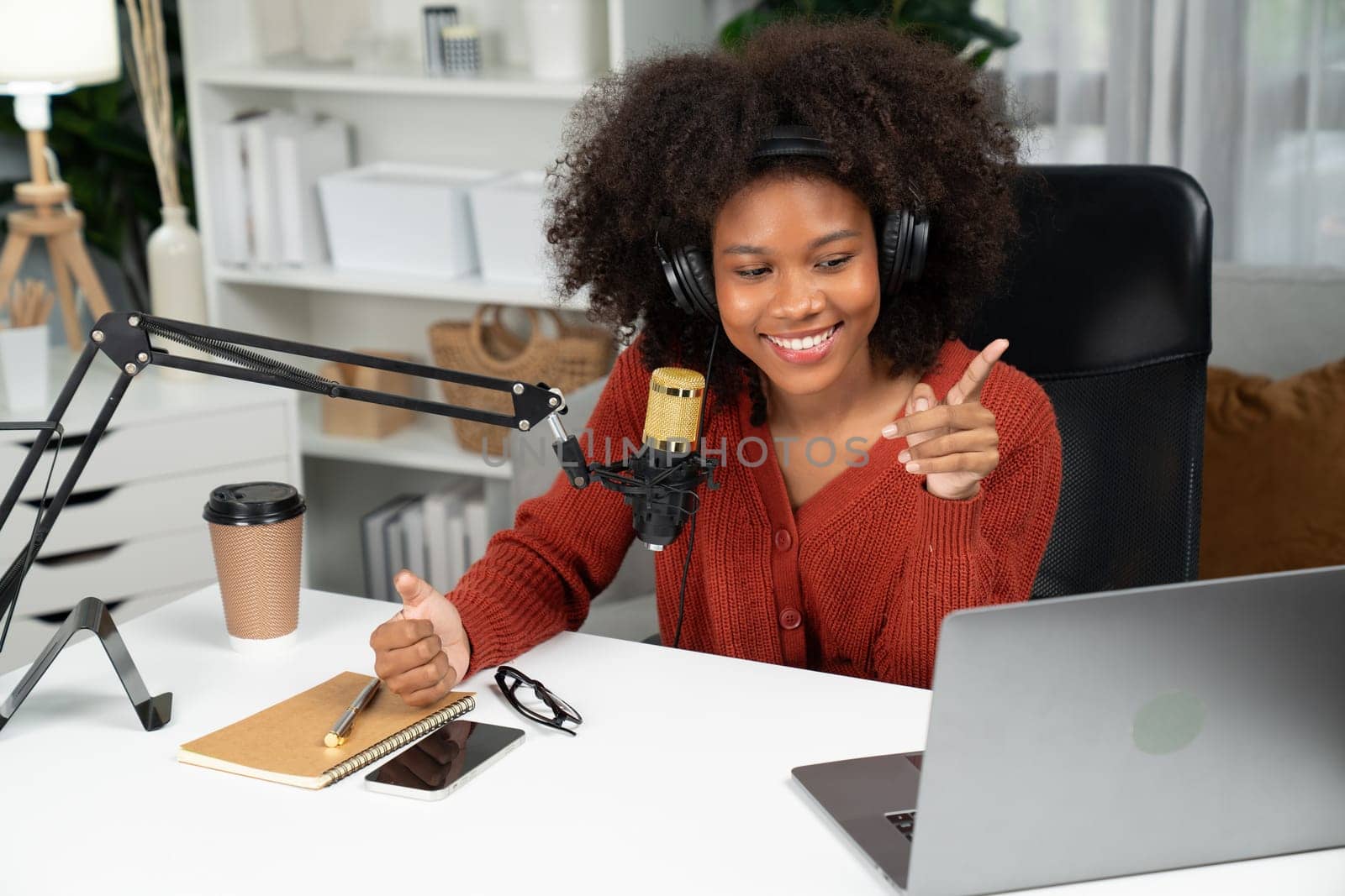 Host channel of beautiful African woman talking in online broadcast teaching marketing influencer, with listeners in broadcast or online. Concept of anywhere at work place. Tastemaker.