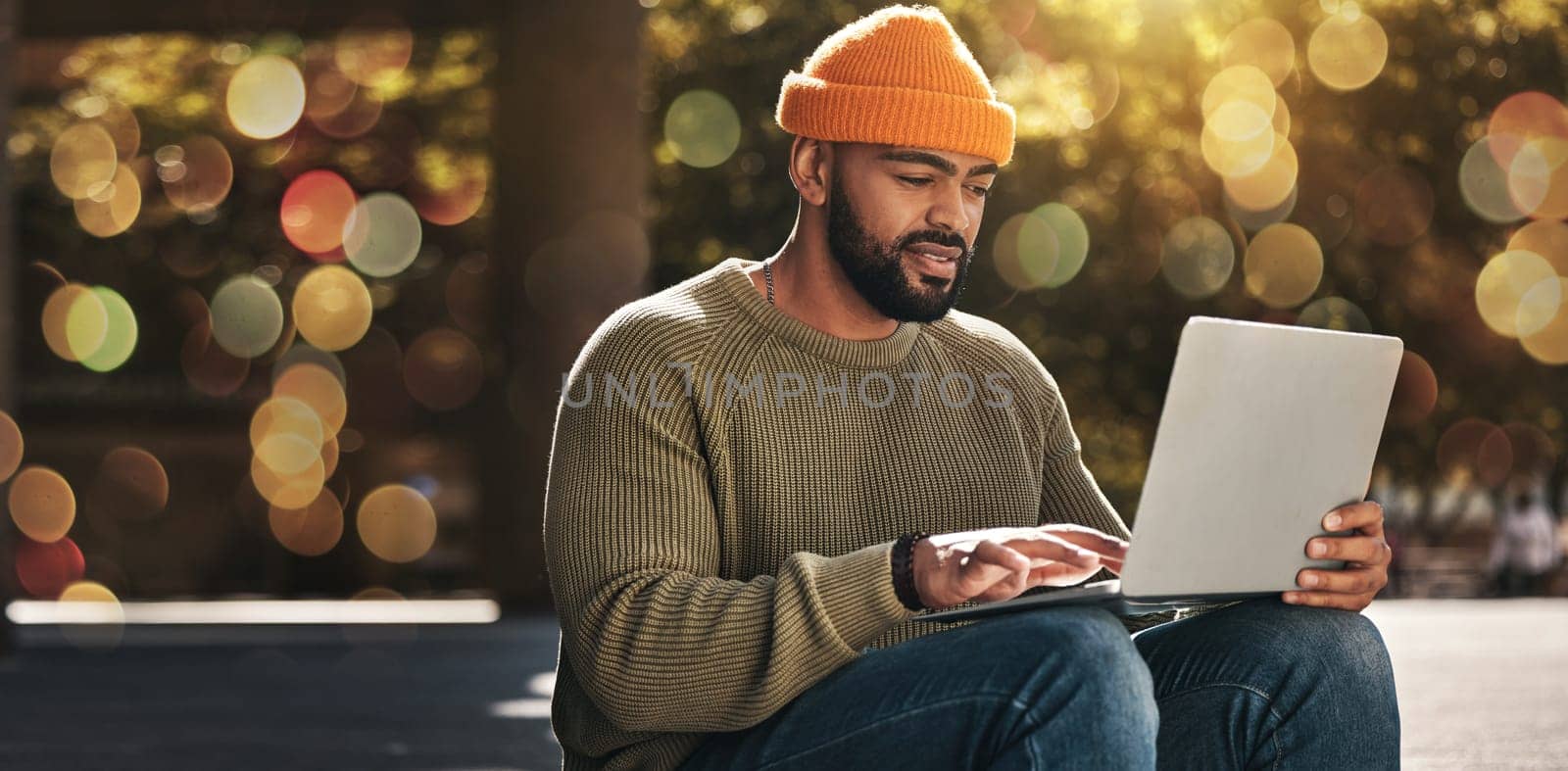 Student, man and computer at outdoor campus for university, college and scholarship research or studying in park. African person on laptop streaming for online education, website or e learning banner.