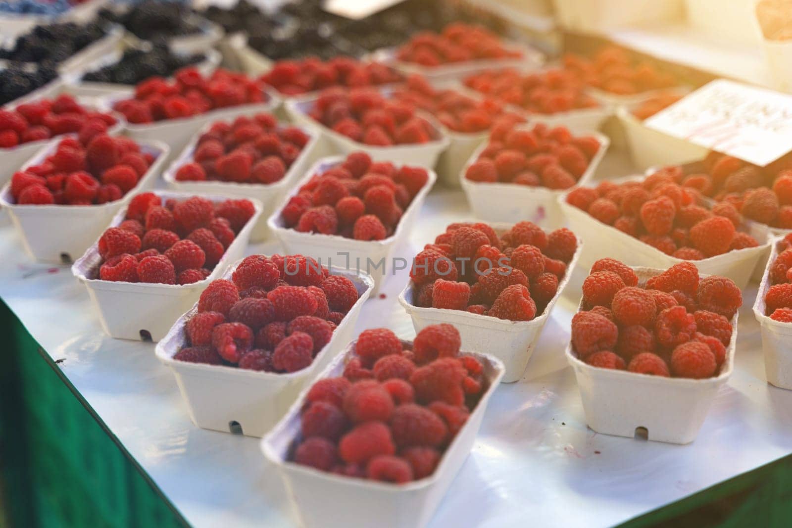 Raspberries in plastic containers on a market counter. by Sd28DimoN_1976