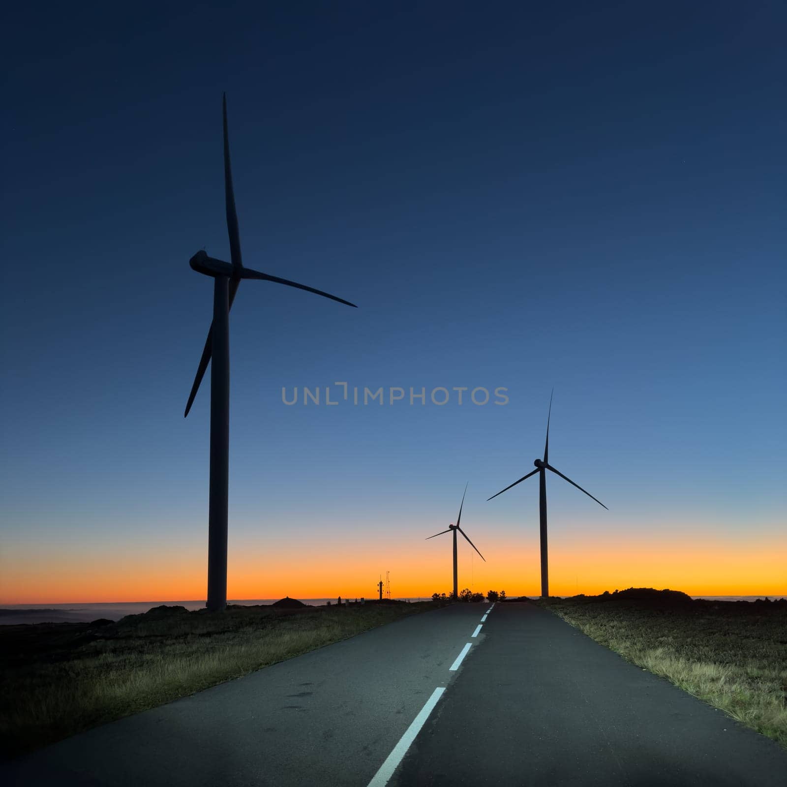 Wind turbines during sunset over a hill in Arouca, Portugal.