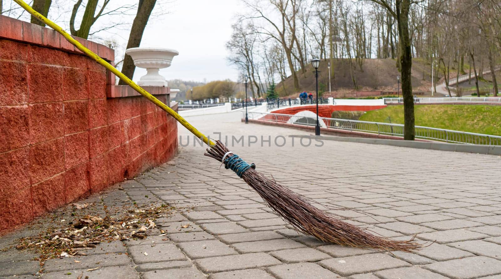 Retro broom made of dry branches against the backdrop of a city park.