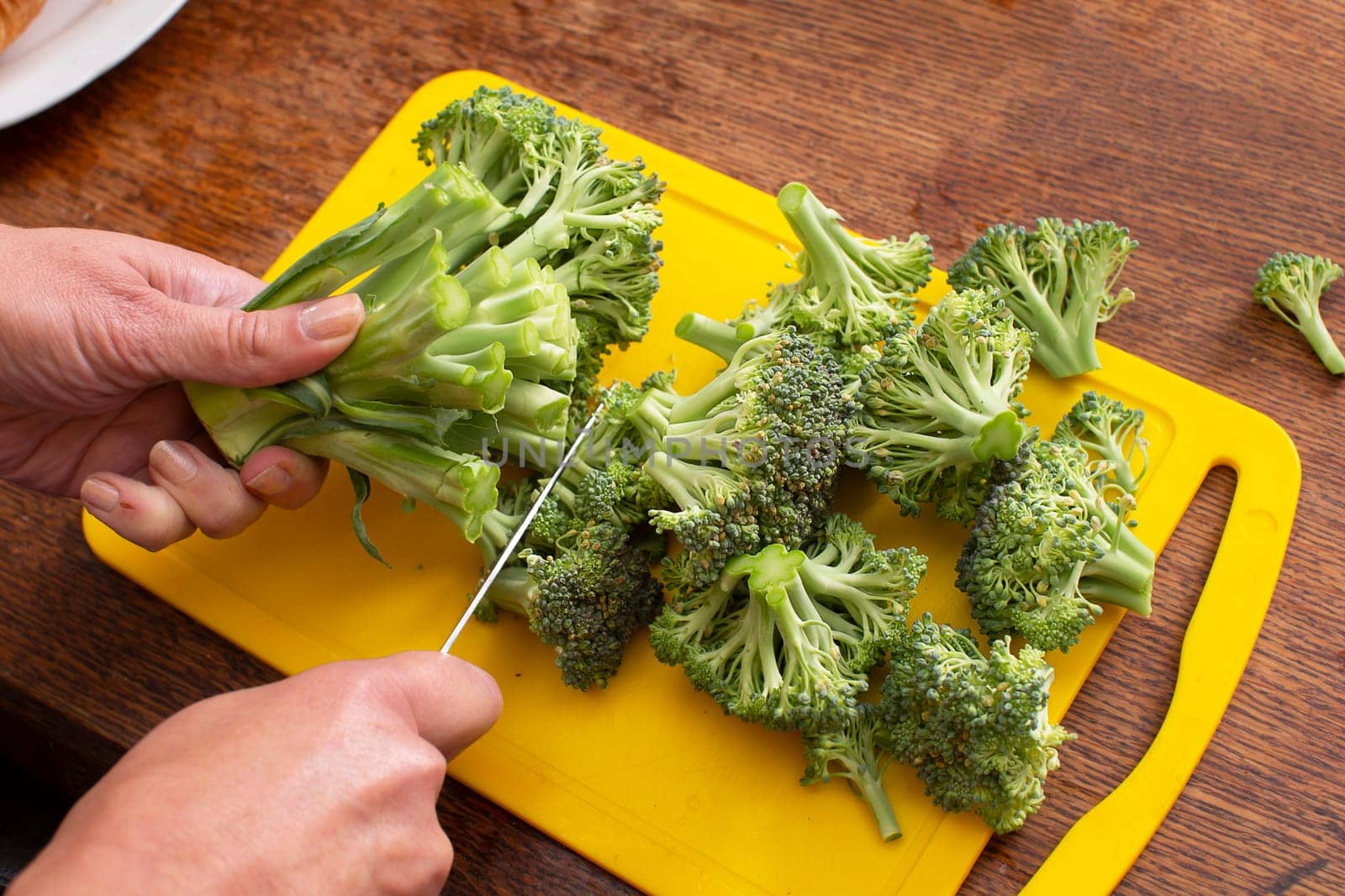 Hands cutting broccoli cabbage. Healthy green vegetables.