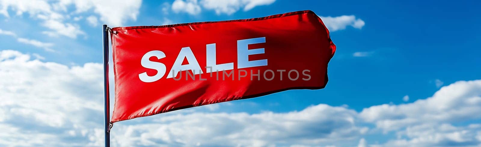 A vibrant red flag boldly displays a sale announcement against a blue sky with fluffy white clouds, attracting attention to a discount event.