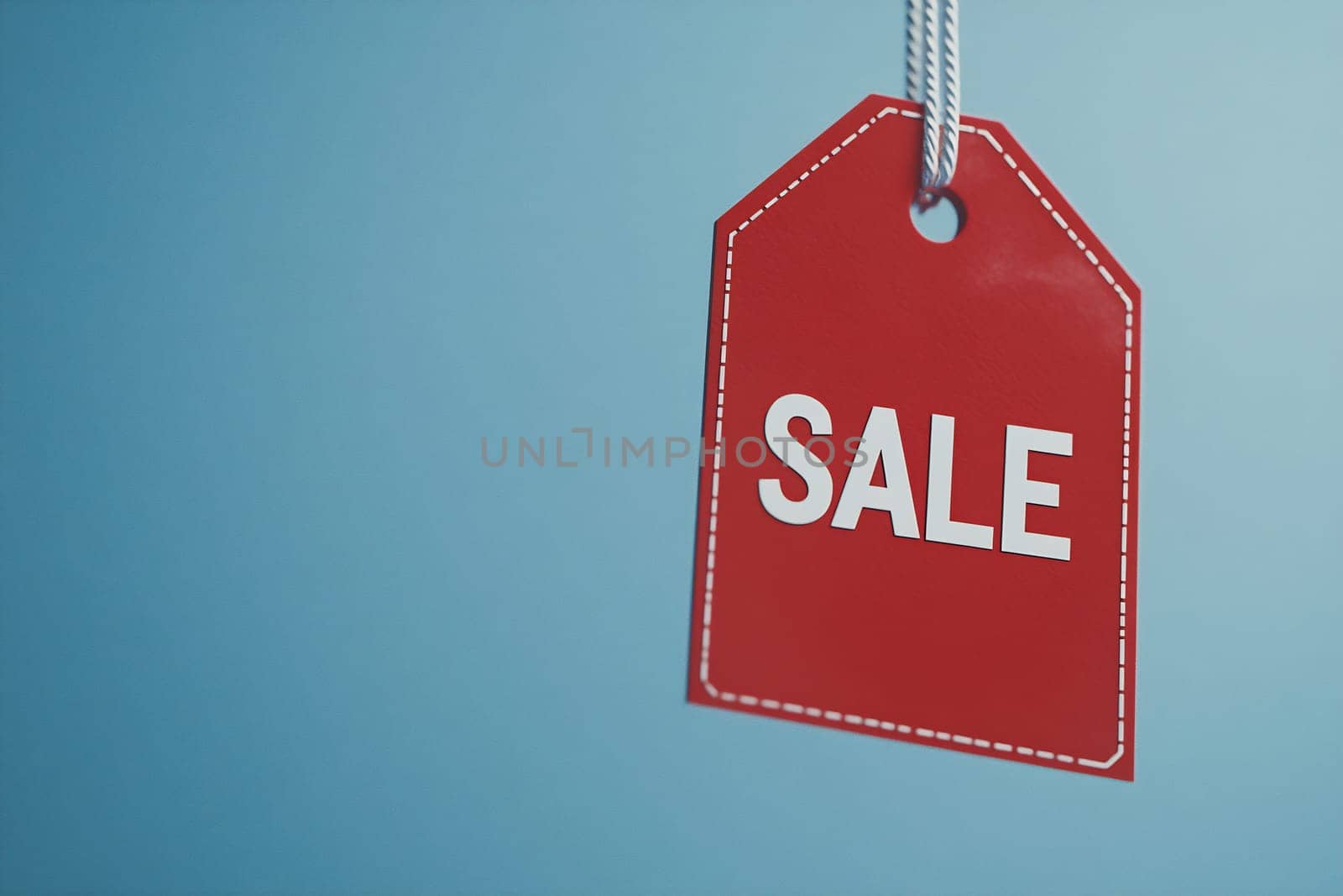 Red sale tag with white letters is suspended against a light blue background, emphasizing the discount opportunity for shoppers.