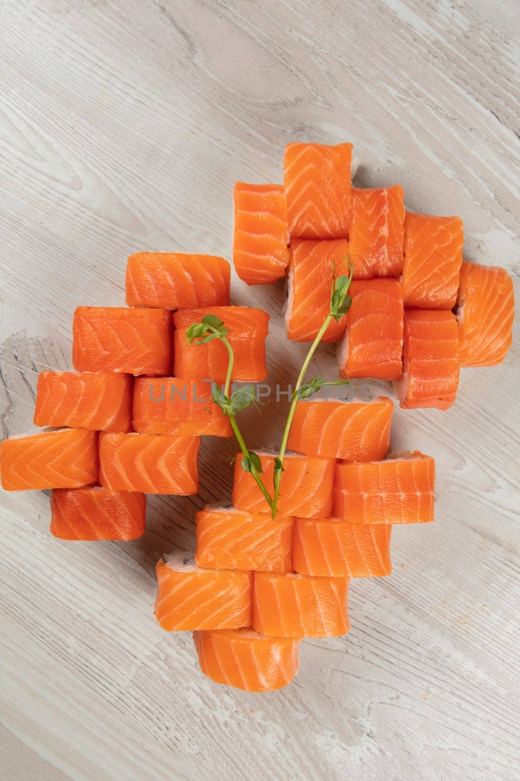 Set of various sushi rolls on a white wooden background close-up.