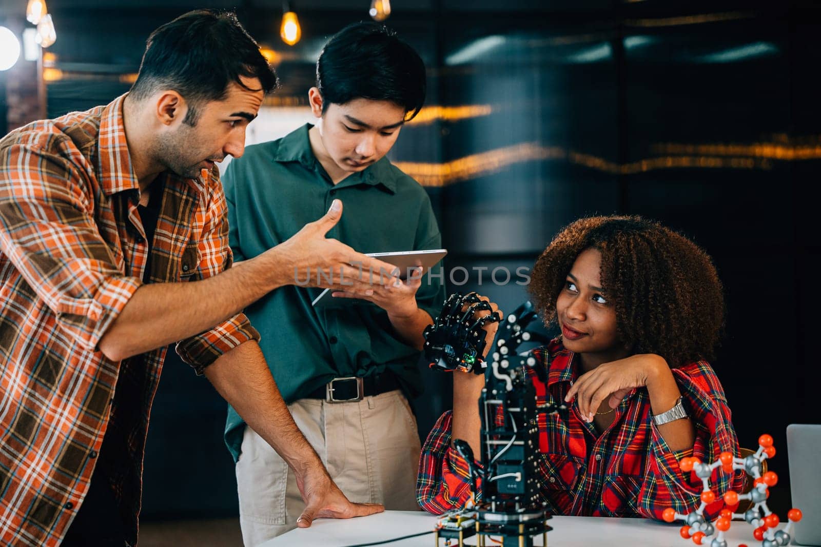 In a classroom setting students and teacher engage in learning on a robotic arm. Fostering innovation teamwork and problem-solving in education. Robot hand. Innovation and technology concept
