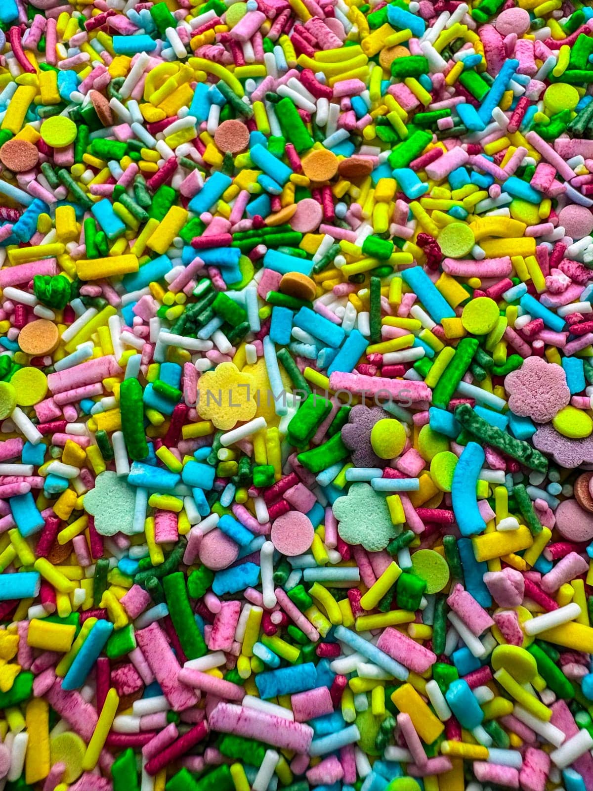 Multicolored small candies of different shapes. Top view. Bright children's background