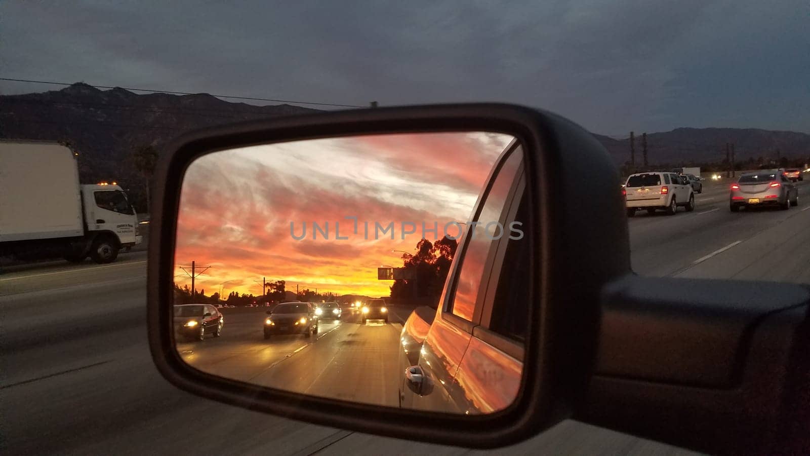 Sunset in the Rear View Mirror of a Pickup Truck on Freeway near Los Angeles. High quality photo