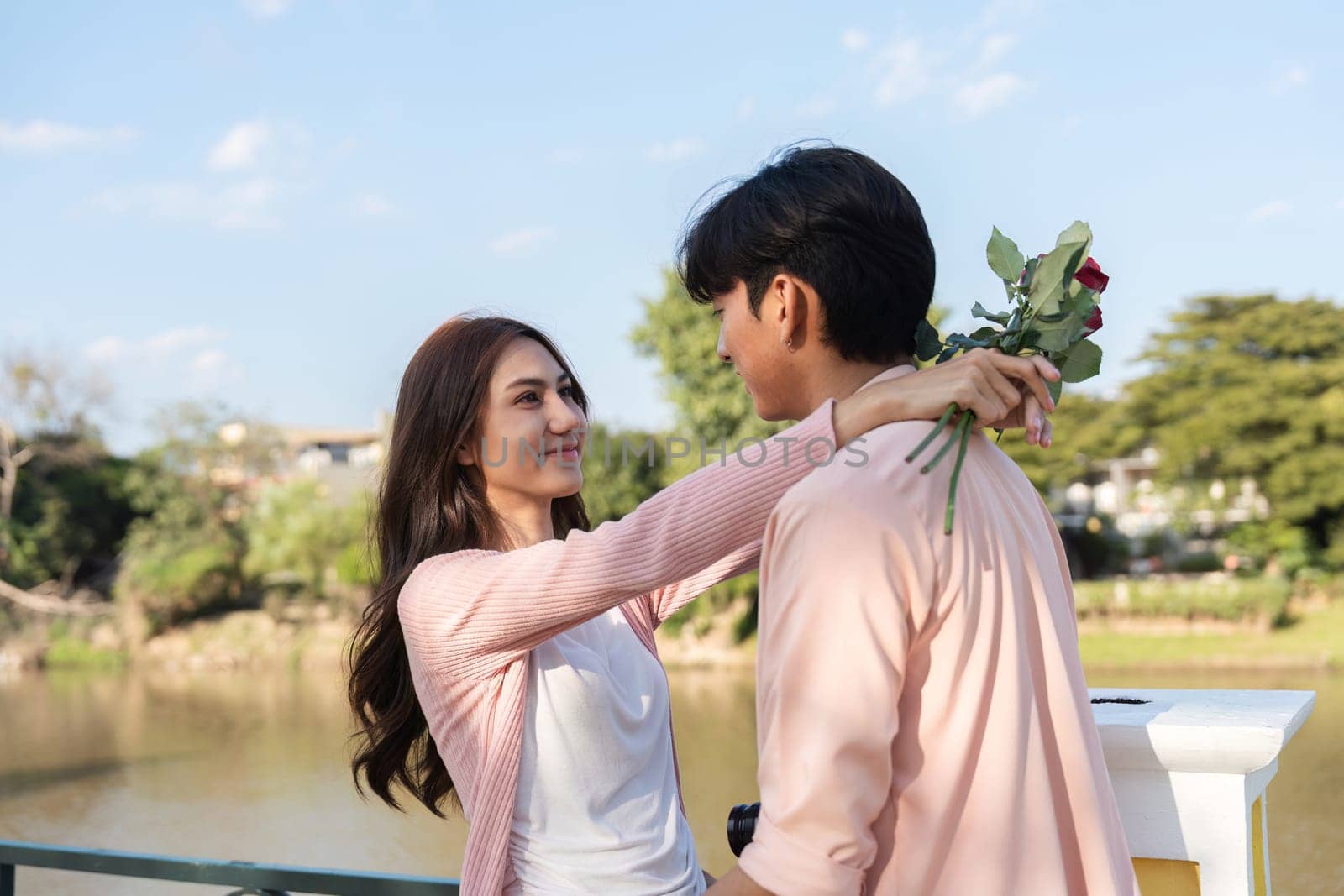 Valentine day surprise a romantic encounter by the river couple embracing with flowers serene setting joyful atmosphere