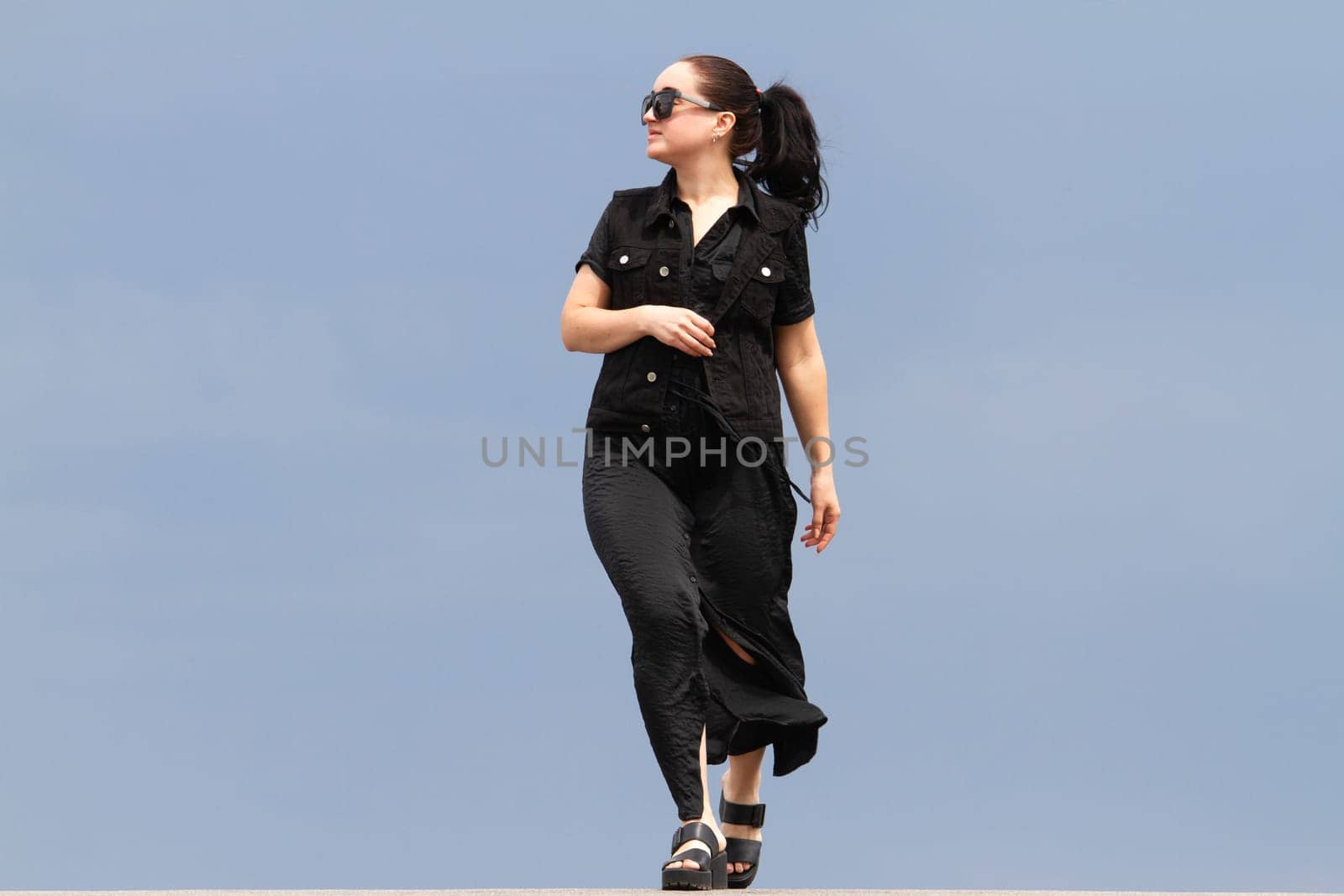 girl in black walking against the sky, emotions and actions