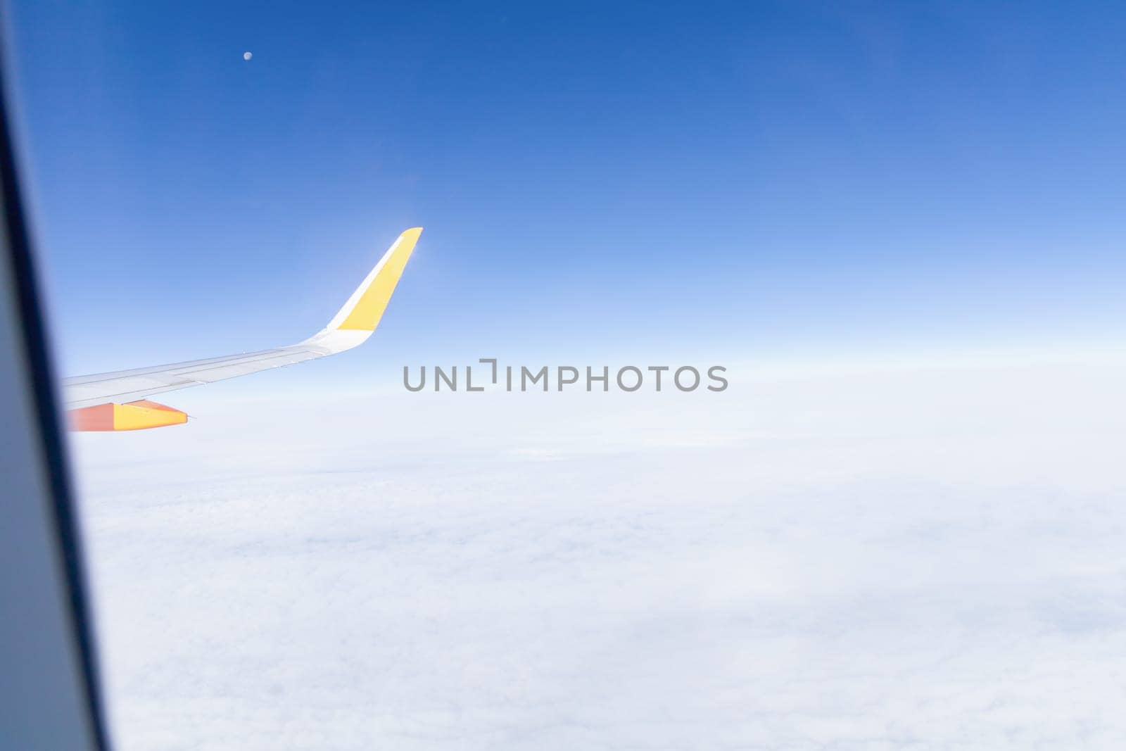 View from airplane window of blue sky with clouds. High quality photo