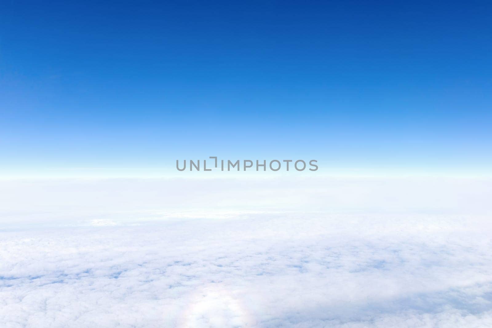 View from airplane window of blue sky with clouds. High quality photo