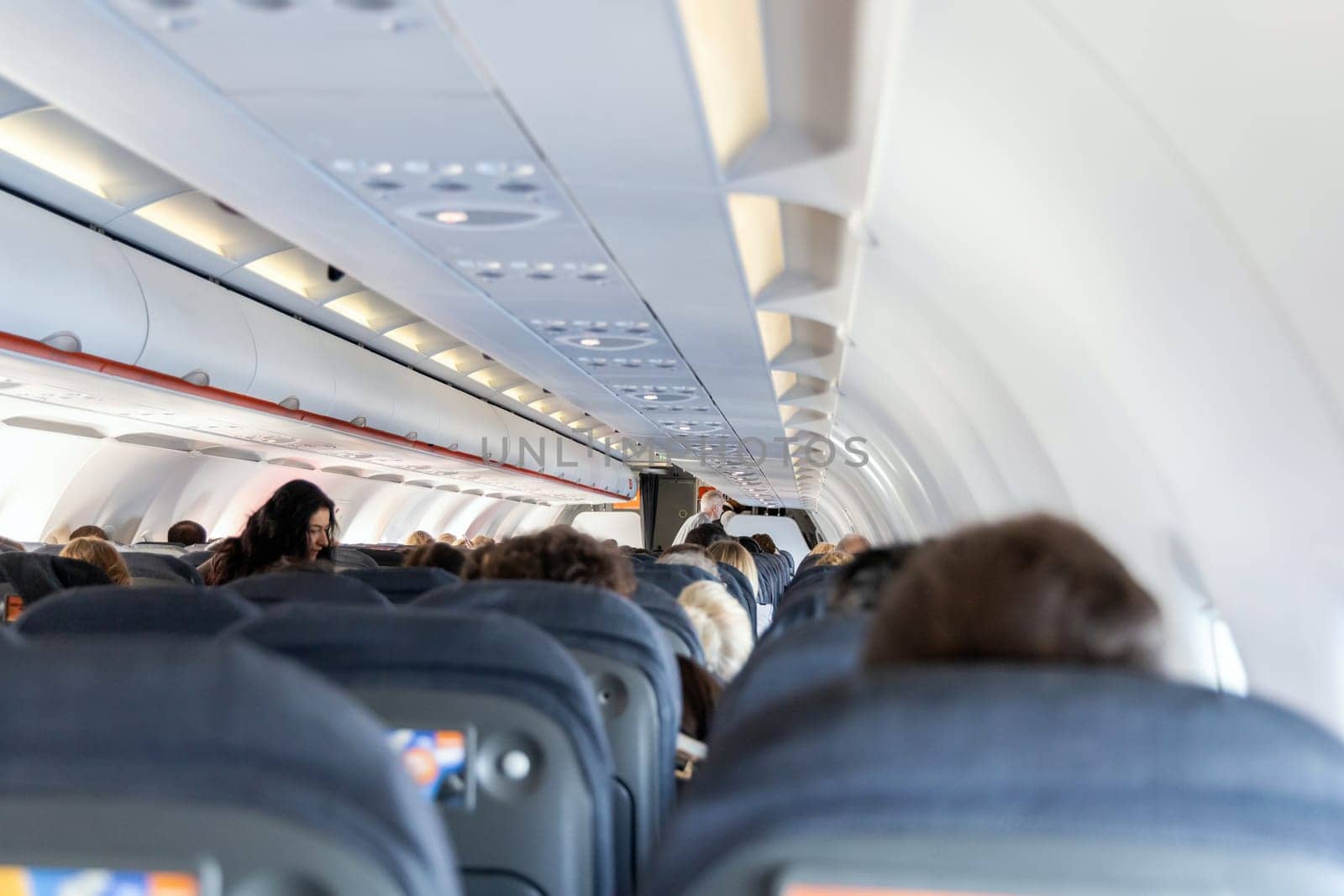 Inside the passenger plane cabin with people. Airplane travel concept. Paris, France - December 6, 2025