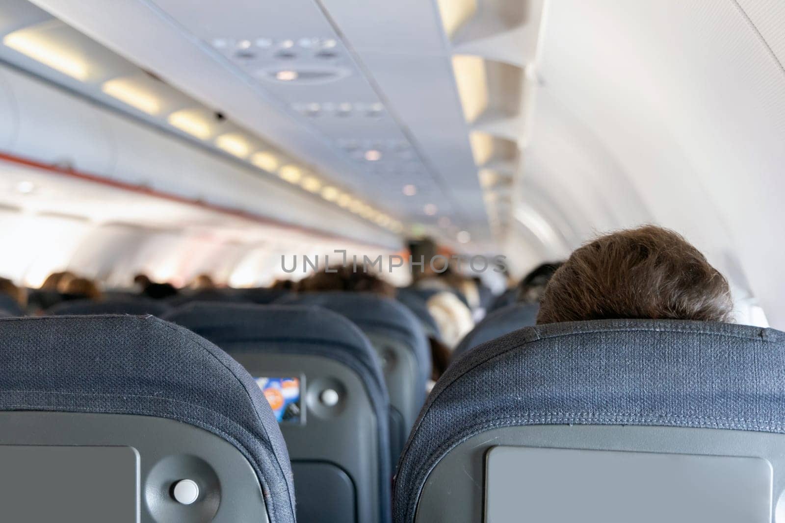 Inside the passenger plane cabin with people. Airplane travel concept.