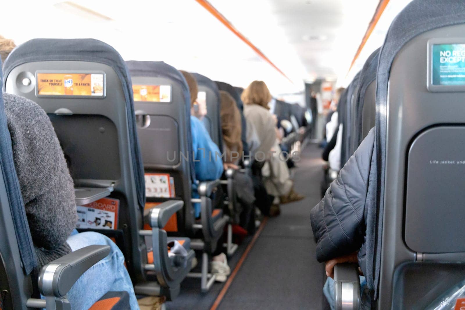 Inside the passenger plane cabin with people. Airplane travel concept. Paris, France - December 6, 2025