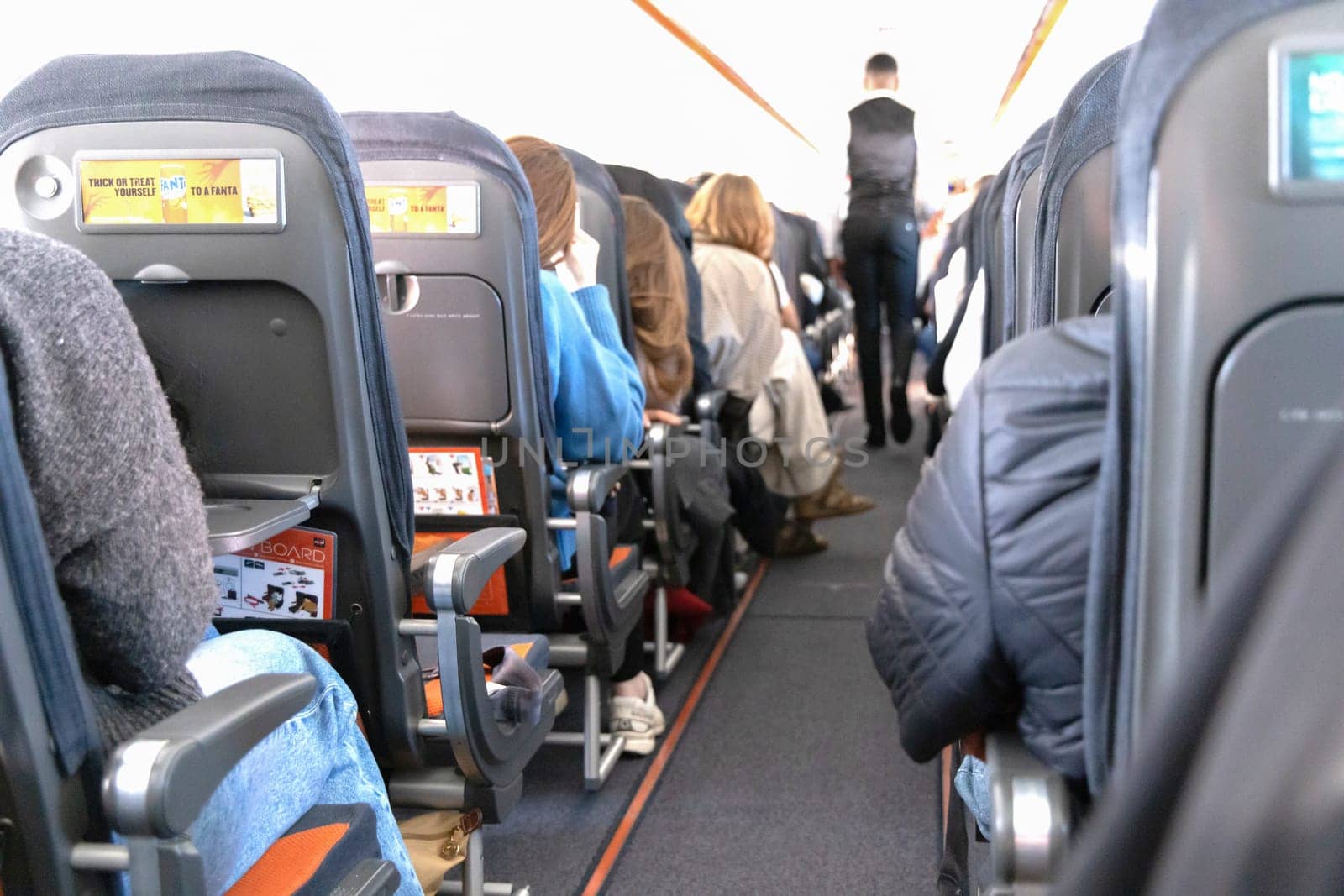 Inside the passenger plane cabin with people. Airplane travel concept. Paris, France - December 6, 2025
