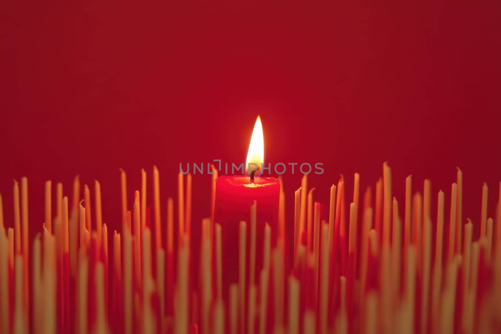One Red Candle on a festive background. Advent, Christmas, holiday and traditions.