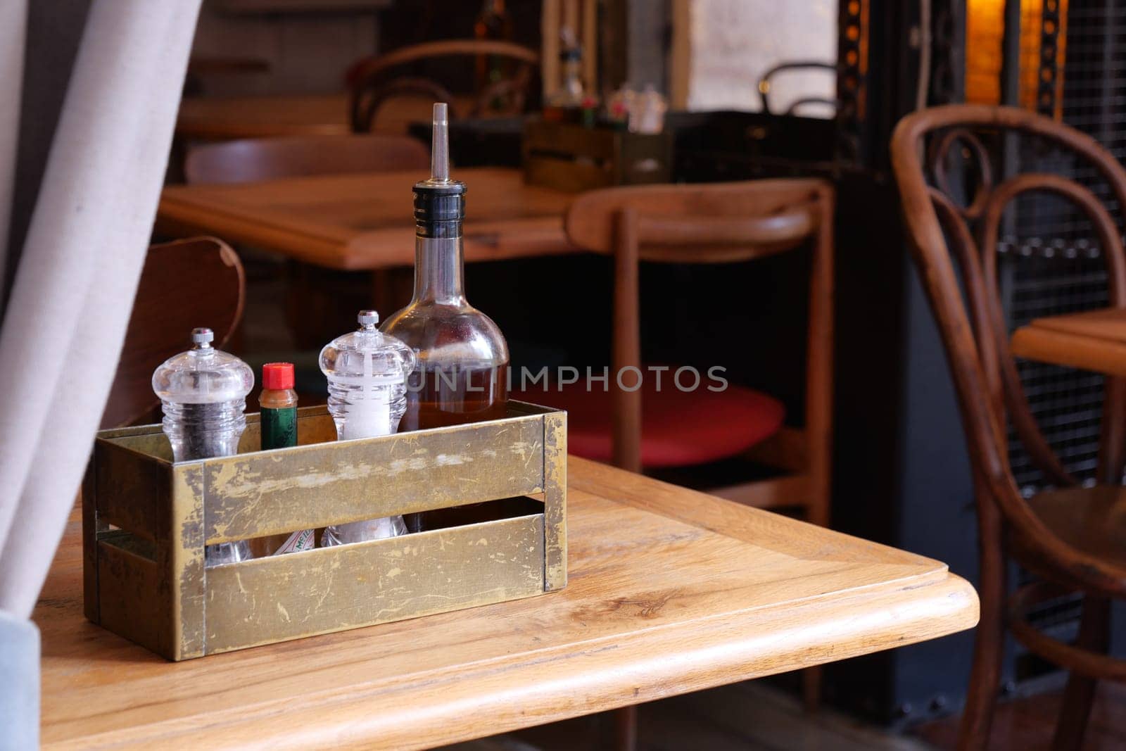 A warm and inviting restaurant scene showcasing a lovely wooden table adorned with condiments