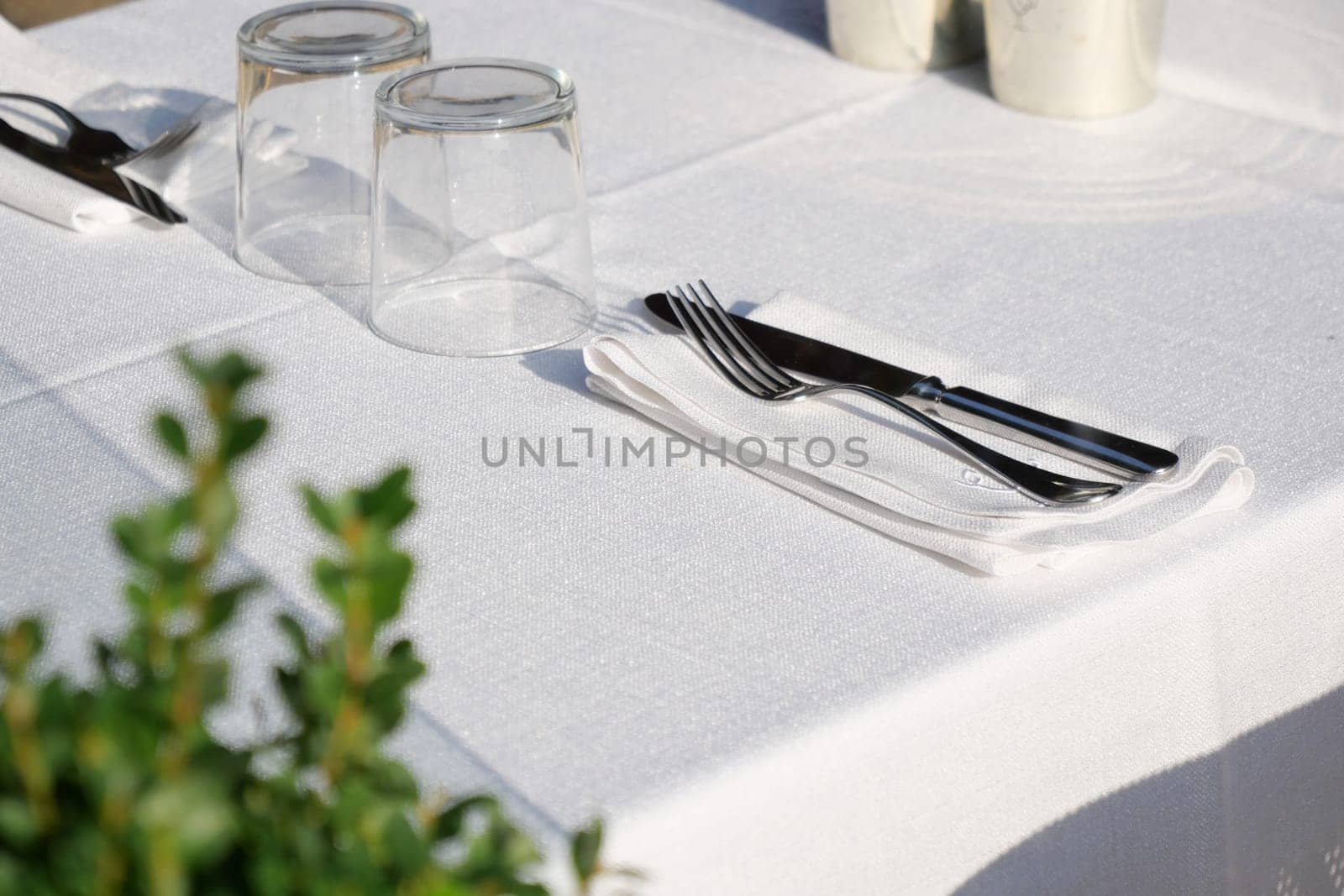 A beautifully arranged dining table set with elegant utensils, fine glassware, and decor