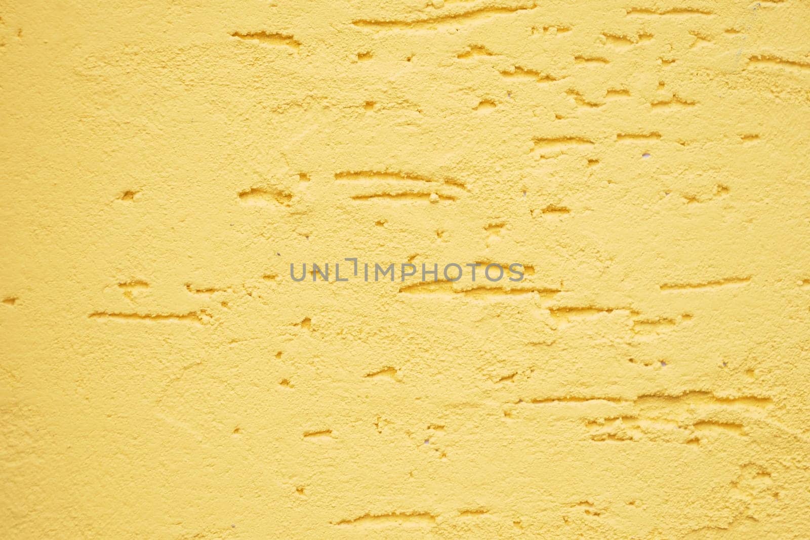 A closeup view of a beautifully textured yellow wall showcasing its unique and intricate patterns