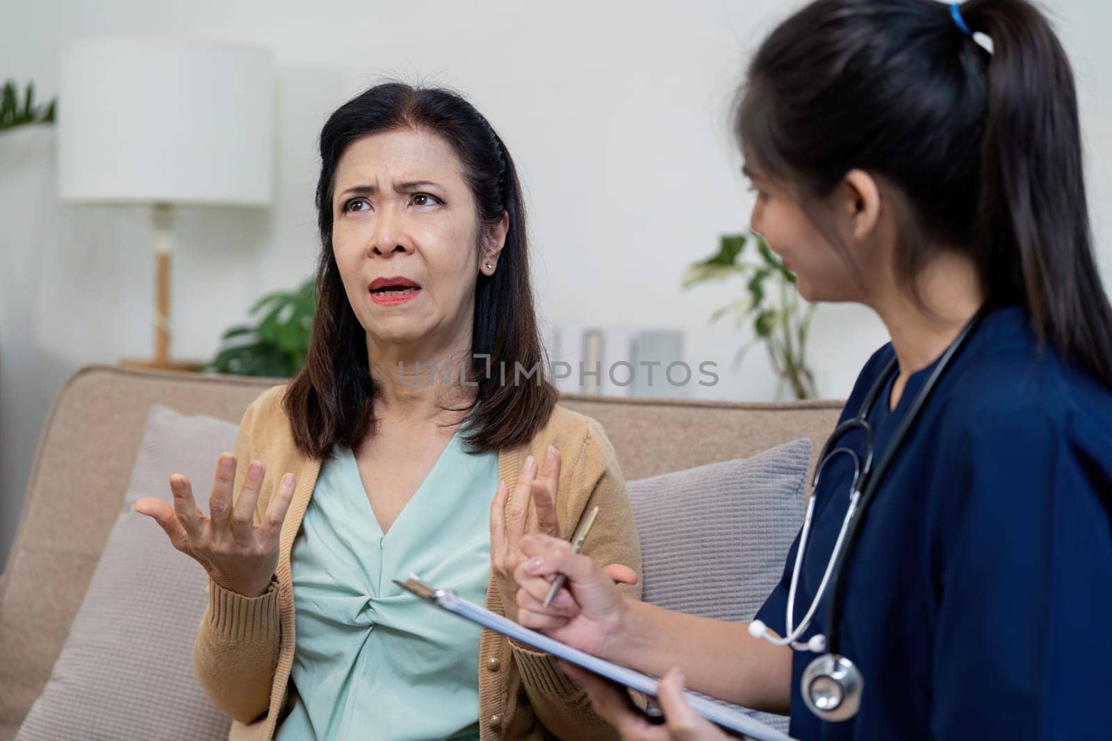 A nurse discusses symptoms with an elderly patient highlighting the importance of caregiver support in healthcare.