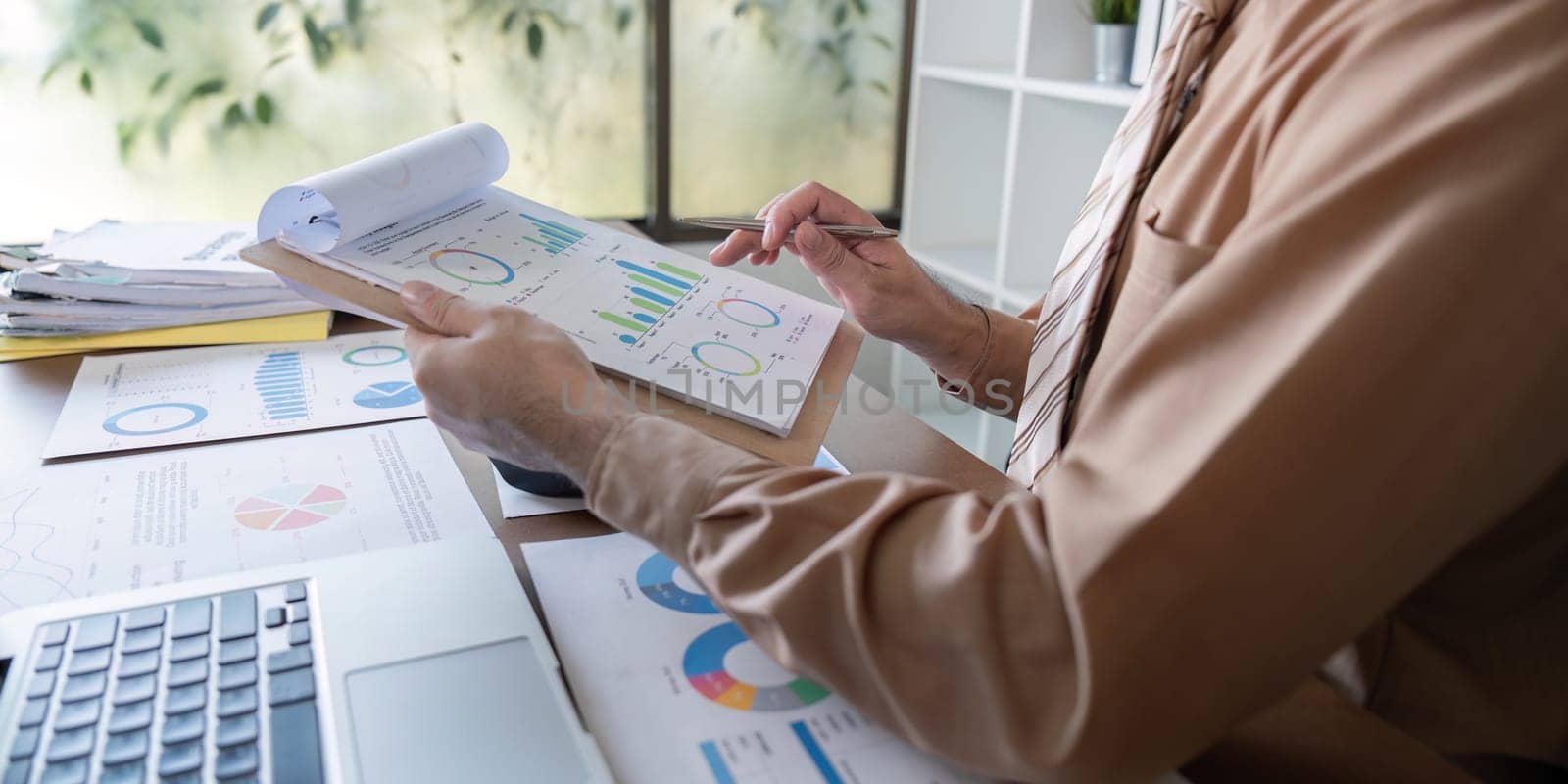 A professional analyzes data reports with charts and graphs in a modern office setting showcasing effective data utilization.