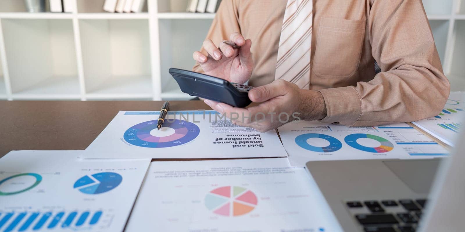 A professional creates a business report using charts and data in an office environment.