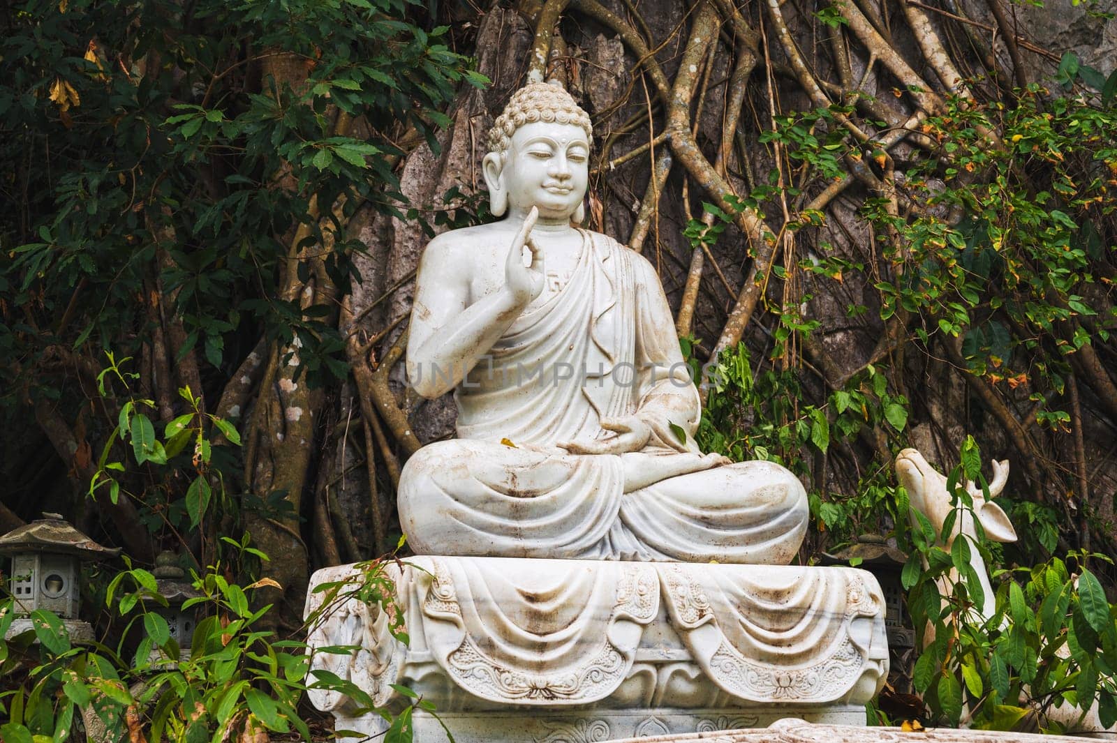 Buddha sculpture in the garden at the pagoda in the marble mountains of Da Nang